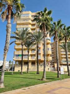 Un gran edificio con palmeras delante. en Blue Water, en La Manga del Mar Menor