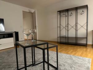 a glass table with two wine glasses on a rug at City Wohnung Zwickau in Zwickau +16 photos