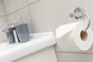 a bathroom with a toilet and a toilet paper dispenser at Southwark & Bermondsey City Apt 5 in London