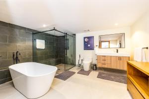 a bathroom with a tub and a shower and a sink at Sienna I Long Bay Retreat I Luxury Stay Near Grace Bay & Long Bay Beach in Long Bay Hills +11 photos