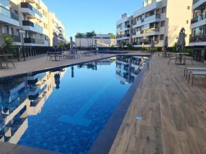 a swimming pool with tables and chairs next to buildings at Mar de ensueños in Florianópolis