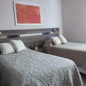 a hotel room with two beds and a painting on the wall at By Muni Apartamentos Premium in Tanti +33 photos
