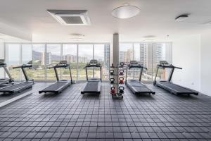 a gym with a row of treadmills and a large window at Aparta suite Playa Bello Horizonte Santa Marta in Santa Marta