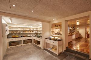 a large kitchen with white cabinets and shelves at Hotel Rössle in Au im Bregenzerwald