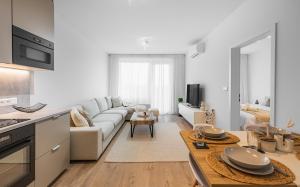 a white living room with a couch and a table at BNB Urban Oasis Bajkalska in Bratislava