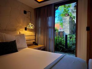 a bedroom with a bed and a large window at Hotel Boutique Casa Laja in San Miguel de Allende