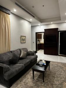 a living room with a couch and a coffee table at شقق البيوتات المميزة للشقق المخدومة in Jeddah
