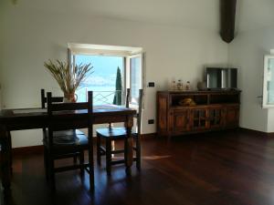 a dining room with a table and a television at Casa Beatrice in Oliveto Lario