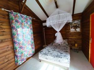 Giường trong phòng chung tại Le Paradis des Colibris Gîte créole avec piscine table dhôtes et nature à Anse Bertrand