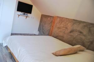 ein Bett mit einem Kissen darüber in der Unterkunft Chalet Au Cottage des Lynx in Xonrupt-Longemer