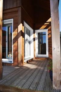 eine Veranda eines Holzhauses mit Fenstern in der Unterkunft Chalet Au Cottage des Lynx in Xonrupt-Longemer + 4 Fotos