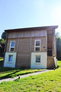 ein Haus mit einem Rasen davor in der Unterkunft Chalet Au Cottage des Lynx in Xonrupt-Longemer
