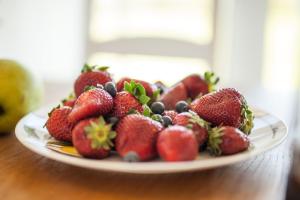 un plato de fresas y arándanos sobre una mesa en Holmiranna Holiday Homes, en Kungla