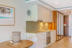 a kitchen with a table with a vase on it at 105 Santai - Ground Floor Studio Apartment by uHoliday in Casuarina