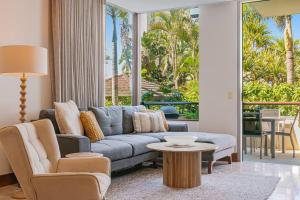 a living room with a blue couch and a table at 105 Santai - Ground Floor Studio Apartment by uHoliday in Casuarina