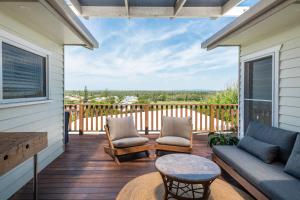 a porch with a couch and chairs on a deck at Sunset House - Oceanstays in Yamba +48 photos