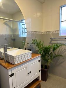 a bathroom with a sink and a mirror at Apê Coloridinho - Centro in Serra Negra +54 photos