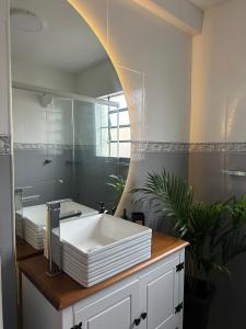 a bathroom with a white sink and a mirror at Apê Coloridinho - Centro in Serra Negra