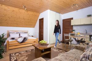 a woman standing in a living room with a bed at Apartmány Lipka in Pavčina Lehota