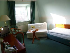 Habitación de hotel con cama, mesa y ventana en Hotel Brandenburg en Königs Wusterhausen