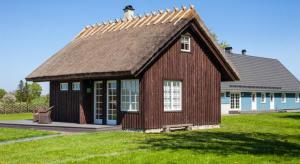 una pequeña casa con techo en un campo verde en Holmiranna Holiday Homes, en Kungla