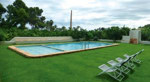 a swimming pool with two lawn chairs and a pair at El Sequer Casa Rural in Oliva