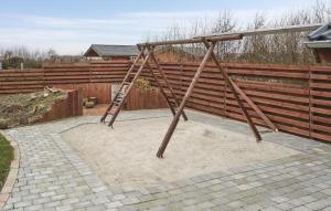 a wooden swing set in a yard with a fence at Holiday Home Hulvej Vinderup Vi in Vinderup