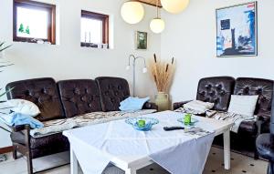 a living room with a table and leather chairs at Holiday Home Hulvej Vinderup Vi in Vinderup