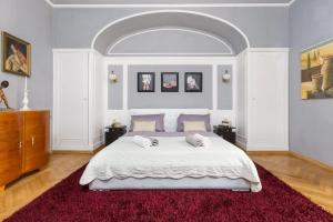 Un dormitorio con una gran cama blanca y una alfombra roja en Riva Waterfront Apartments en Split