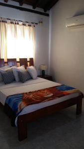 een slaapkamer met een groot bed en een raam bij Hotel Casa De España in Mompos