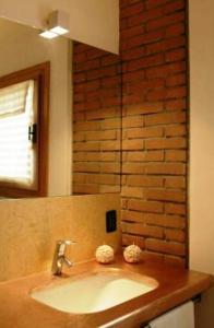 BrendolaにあるTenuta Maravejaのレンガの壁、洗面台付きのバスルーム