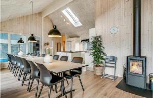 una sala da pranzo con tavolo, sedie e camino di Cozy Home In Nørre Nebel With Sauna a Nørre Nebel
