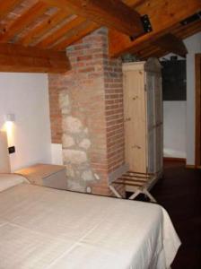 um quarto com uma cama e uma parede de tijolos em Tenuta Maraveja em Brendola