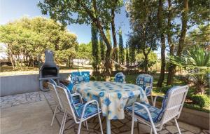 einen Tisch und Stühle mit einem Tisch und einem Kamin in der Unterkunft Two-Bedroom Apartment In Betiga in Barbariga