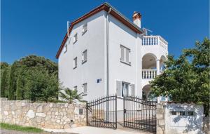 ein weißes Haus mit einem Tor und einem Zaun in der Unterkunft Two-Bedroom Apartment In Betiga in Barbariga
