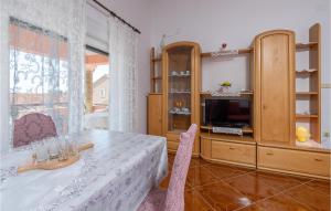 una sala da pranzo con un tavolo e una televisione di Holiday Apartment Betiga 03 a Barbariga