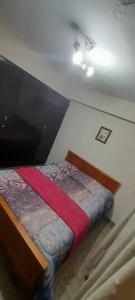a bedroom with a bed with a red blanket at Departamento PyA in San Miguel de Tucumán +24 photos