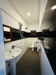a bathroom with a sink and a toilet at Luthmin River View Hotel in Alutgama