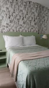 een slaapkamer met een bed met een bloemenbehang bij comfort hotel 413 anfitriã in Taguatinga