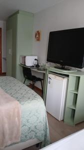 een kamer met een bed en een televisie op een bureau bij comfort hotel 413 anfitriã in Taguatinga