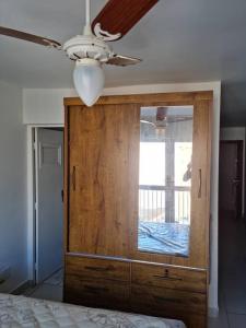 1 dormitorio con armario de madera y ventana en Apartamento Centro Guarapari- ES, en Guarapari