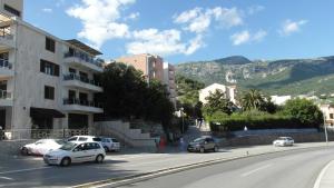 a city street with cars parked on the road at Casa Agava Becici in Bečići