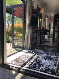 an open door leading to a patio with a rug at Luxury Farm Escape Tiny Home New Plymouth-Egmont Village in Egmont Village