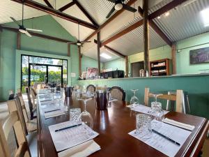 ein Esszimmer mit einem langen Tisch mit Weingläsern in der Unterkunft Cuvee Cottage in Lovedale