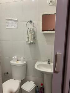 a small bathroom with a toilet and a sink at Casa confortável a 5 minutos da Praia do Forte a pé in Cabo Frio