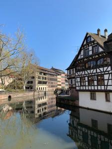 an old building next to a river with buildings at Studio cocoon hypercentre Carré d'or de Strasbourg in Strasbourg