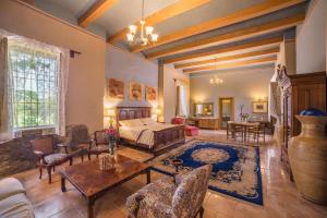 a large room with a bed and a table at Hacienda Labor de Rivera Hotel Boutique & Eventos in Teuchitlán +144 photos