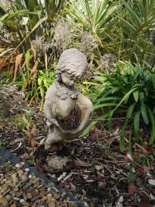 a statue of a little girl sitting on a rock at Rye Holiday Getaway BYO Linen and Towels 750m walk to Beach in Rye