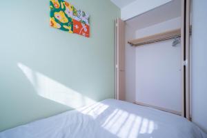 a small bedroom with a bed and a window at Sapporo irios cozy inn in Sapporo +104 photos