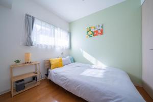 a small bedroom with a bed and a window at Sapporo irios cozy inn in Sapporo